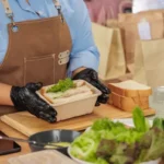What Happens If You Swallow Plastic? Avoid These Dangers 7 Chef preparing fresh meal with greens and bread in a kitchen. Healthy takeout food packaging.