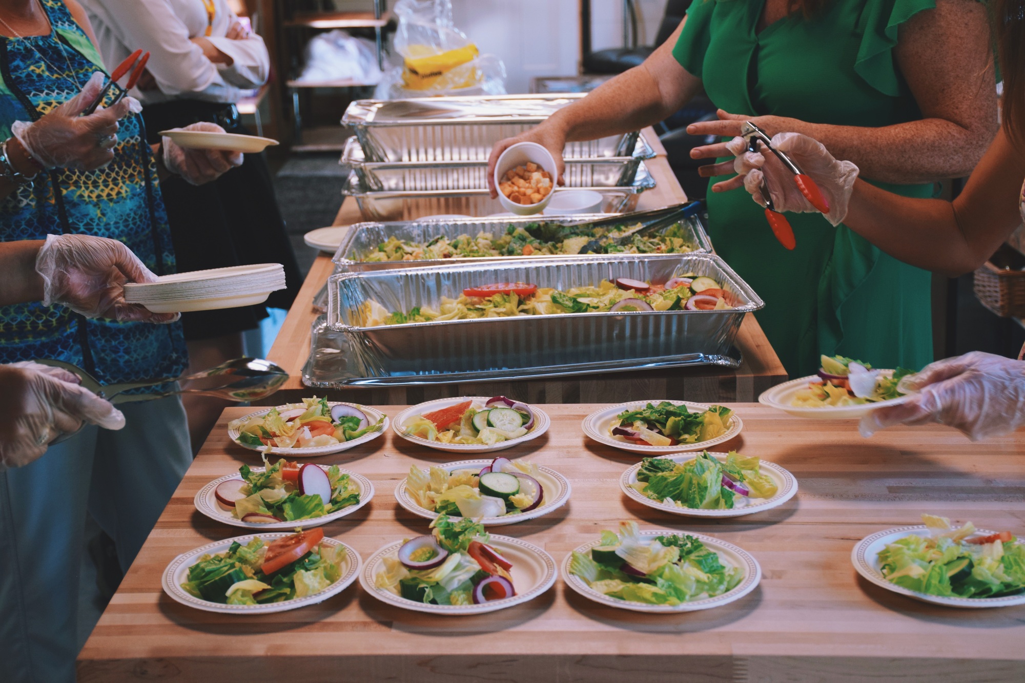 Women volunteers filling up plates with food at a community event