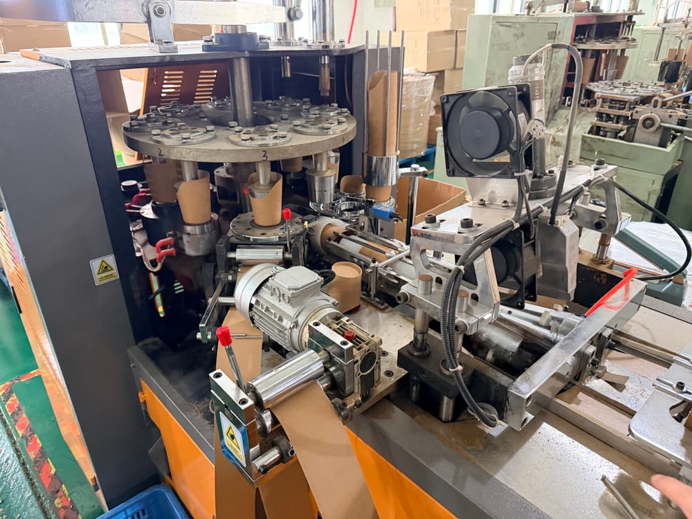 Wilson Wang Profile 16 Kraft paper cups being formed inside a cup-making machine